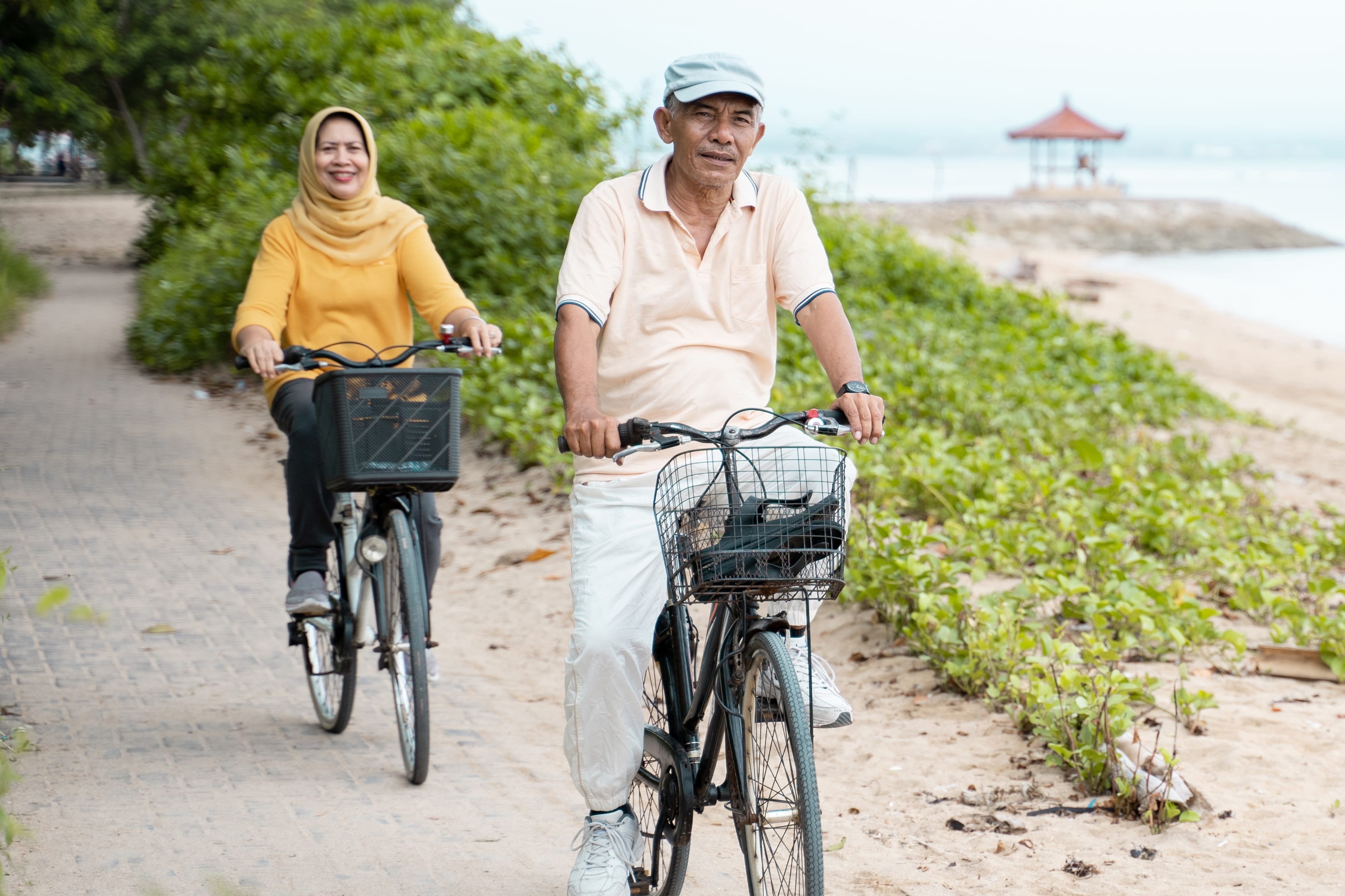 Couple with dialysis cycling on beach as exercise