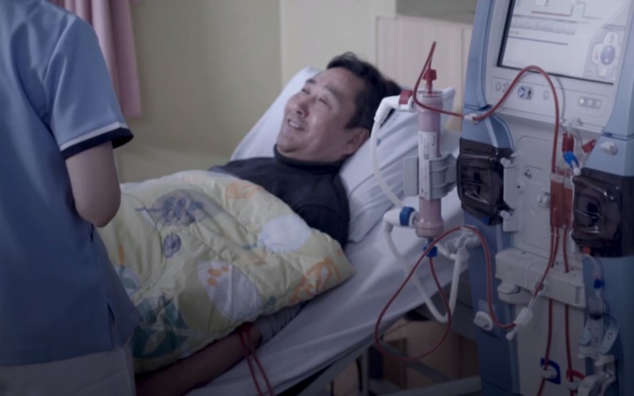 Man lying in treatment bed having hemodialysis