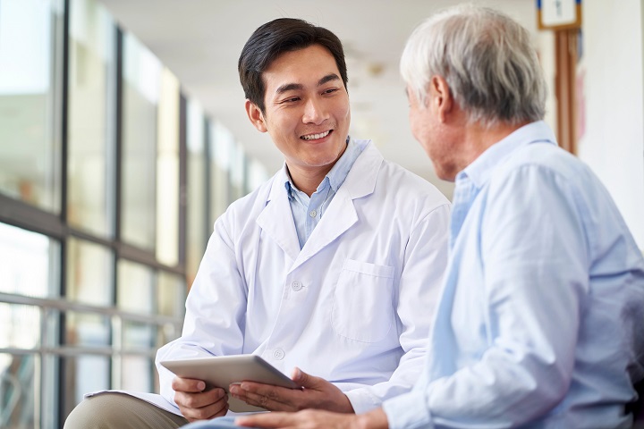 Healthcare worker discussing dialysis treatment with elderly man