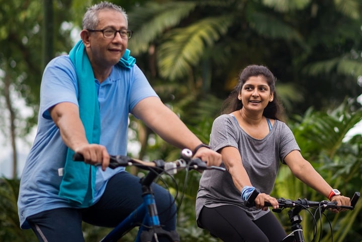 Couple cycling in park after dialysis