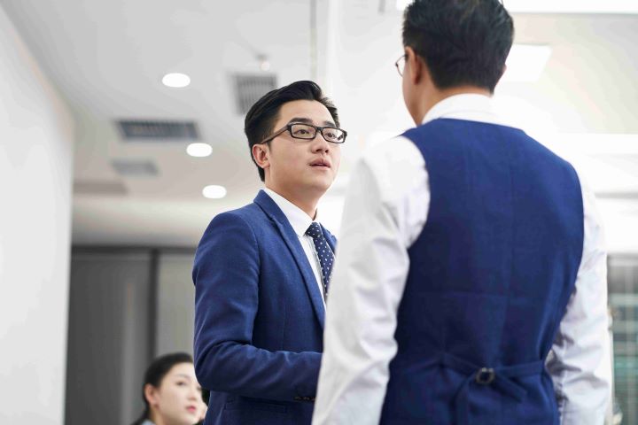 Colleagues in formal wear discussing work in the office