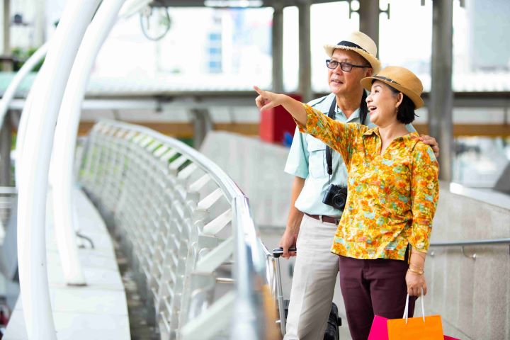 Elderly couple with camera and luggage on travelling with dialysis