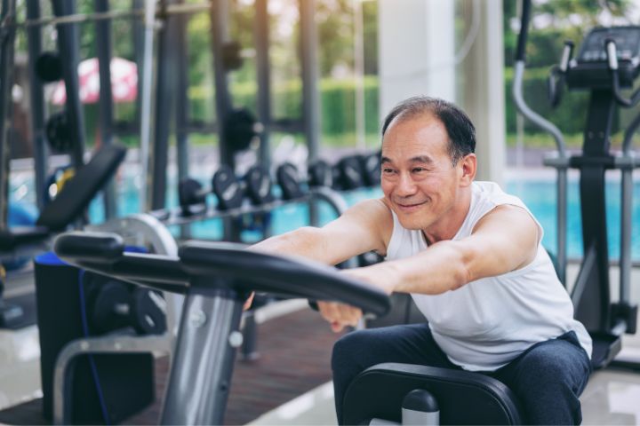 Elderly man exercising in the gym while on dialysis