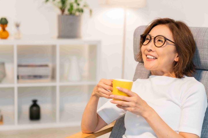 Woman in glasses holding cup thinking about dialysis diet guidelines