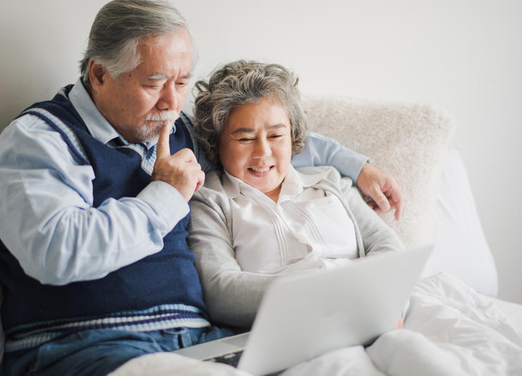 Couple discussing kidney disease treatment options with laptop
